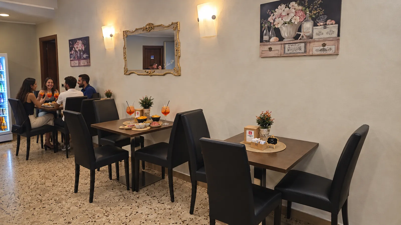 Tavolo apparecchiato per l’aperitivo con calici di Spritz e stuzzichini
